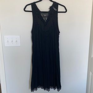 Sleeveless black dress with lace details.